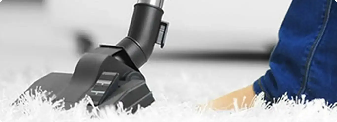 Close-up of a professional vacuuming a white carpet in Cottondale.